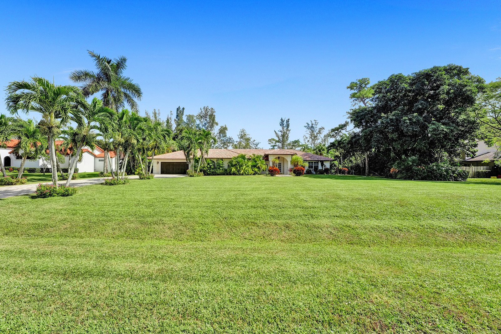 Resort-style pool and private red-clay tennis court framed by royal palms